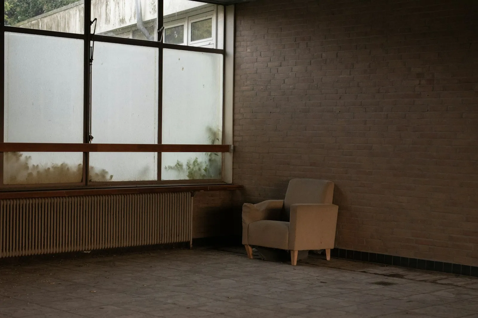 A quiet, empty chair by a window in cool daylight